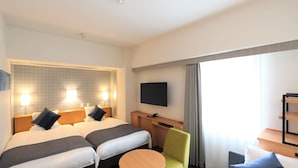 Une chambre d’hôtel avec deux lits, une télévision, un bureau et une chaise.