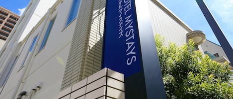 A hotel sign with the name "HOTEL MYSTAYS" in a foreign language, indicating a hotel with international services.