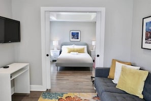Une chambre d’hôtel avec un lit, un bureau, un canapé et une télévision.