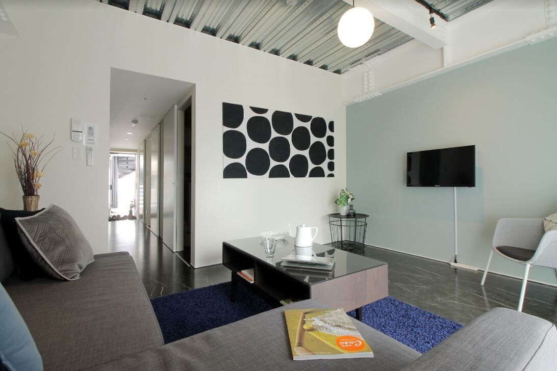A modern living room with a sofa, coffee table, and a flat-screen TV.