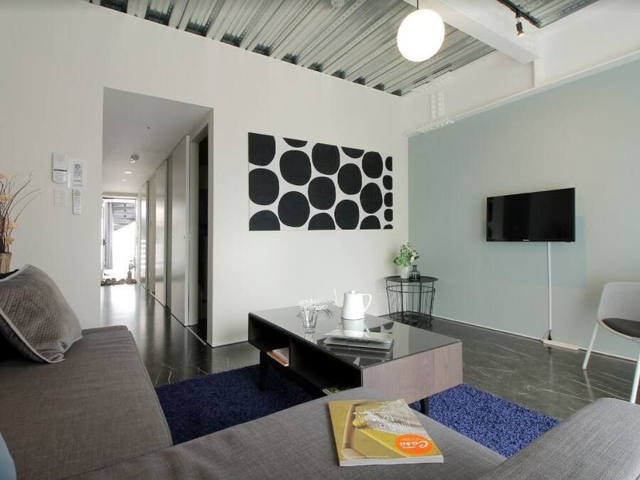 A modern living room with a sofa, coffee table, and a flat-screen TV.