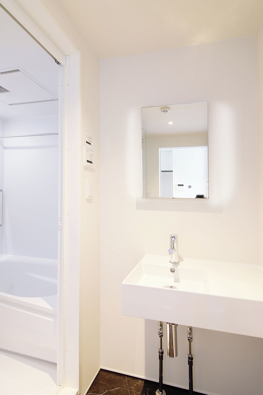 A bathroom with a white sink, mirror, and shower.