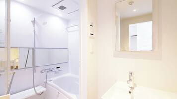 A modern bathroom with a bathtub, a shower, a sink, and a mirror.
