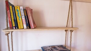 A wooden bookshelf with two shelves, one holding books and the other a single book.