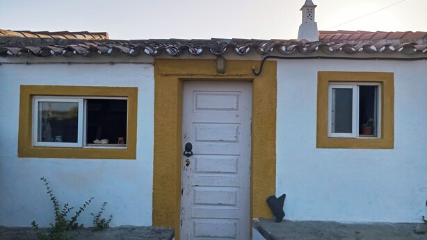 A white building with yellow trim around windows and a door.