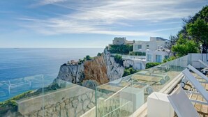 A glass balustrade overlooking a cliff with a view of the sea and modern buildings. - Villa Terrace sur Mer by Interhome (Jávea)
