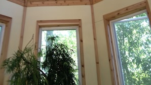 Ein Zimmer mit Holzbalkendecke, Oberlicht und drei Fenstern.