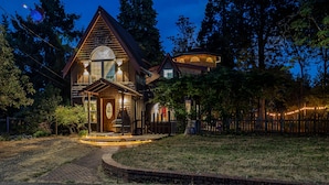 Ein zweistöckiges Haus mit breitem Veranda und einem Rundfenster im zweiten Stock.