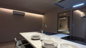 A modern kitchen with a central island, built-in appliances, and a minimalist design. - Marumasa 201 (Hiroshima)