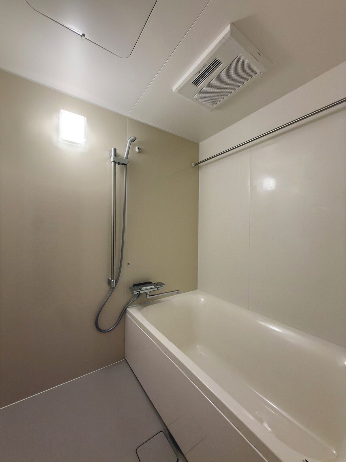 Baño con bañera, ducha y un respiradero en el techo.