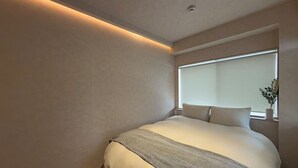 A modern bedroom with a large bed, a bedside table, and a window with a view. - Marumasa 201 (Hiroshima)
