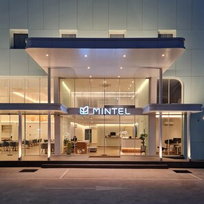 Un edificio moderno con fachada de vidrio y un letrero que dice "MINTEL".