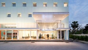 A modern hotel with a flat facade, multiple windows, and a prominent entrance. - Mintel Huamark (Bangkok)