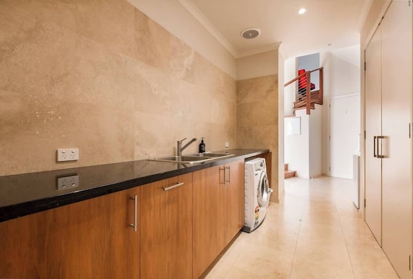 Refresh mid-stay with a full laundry featuring modern appliances, stone finishes, and plenty of storage—perfect for beach towels, weekend gear, or longer visits.