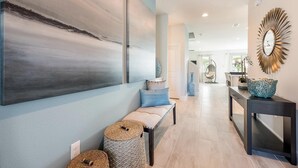 A modern interior with a bench, wicker stools, a console table with a decorative bowl, and a large abstract painting on the wall. - Encore 8BR Villa, Putting Green, Near Disney (Kissimmee)