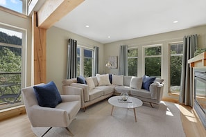 Relax in this spacious living room with a large L-shaped sofa, round coffee table, and armchairs.