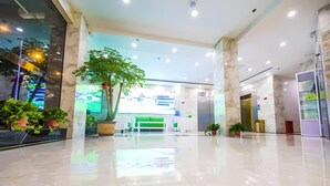 A spacious lobby with a large potted tree, a reception desk, and a modern elevator. - Greentree Inn Chuzhou Langya Mountain Scenic Area Xijian Road (Chuzhou)