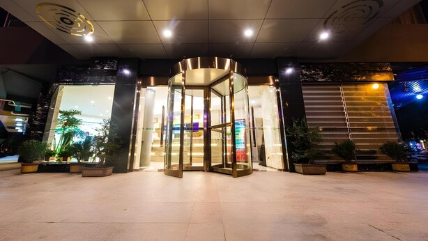 A hotel entrance with a revolving door, potted plants, and a modern ceiling design. - Greentree Inn Chuzhou Langya Mountain Scenic Area Xijian Road (Chuzhou)