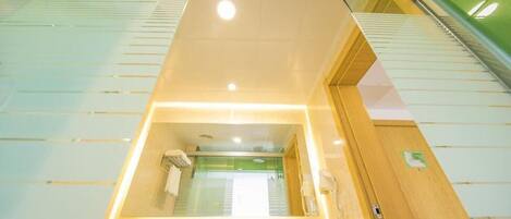 Un baño de hotel con un espejo grande, un lavabo y una zona de ducha.