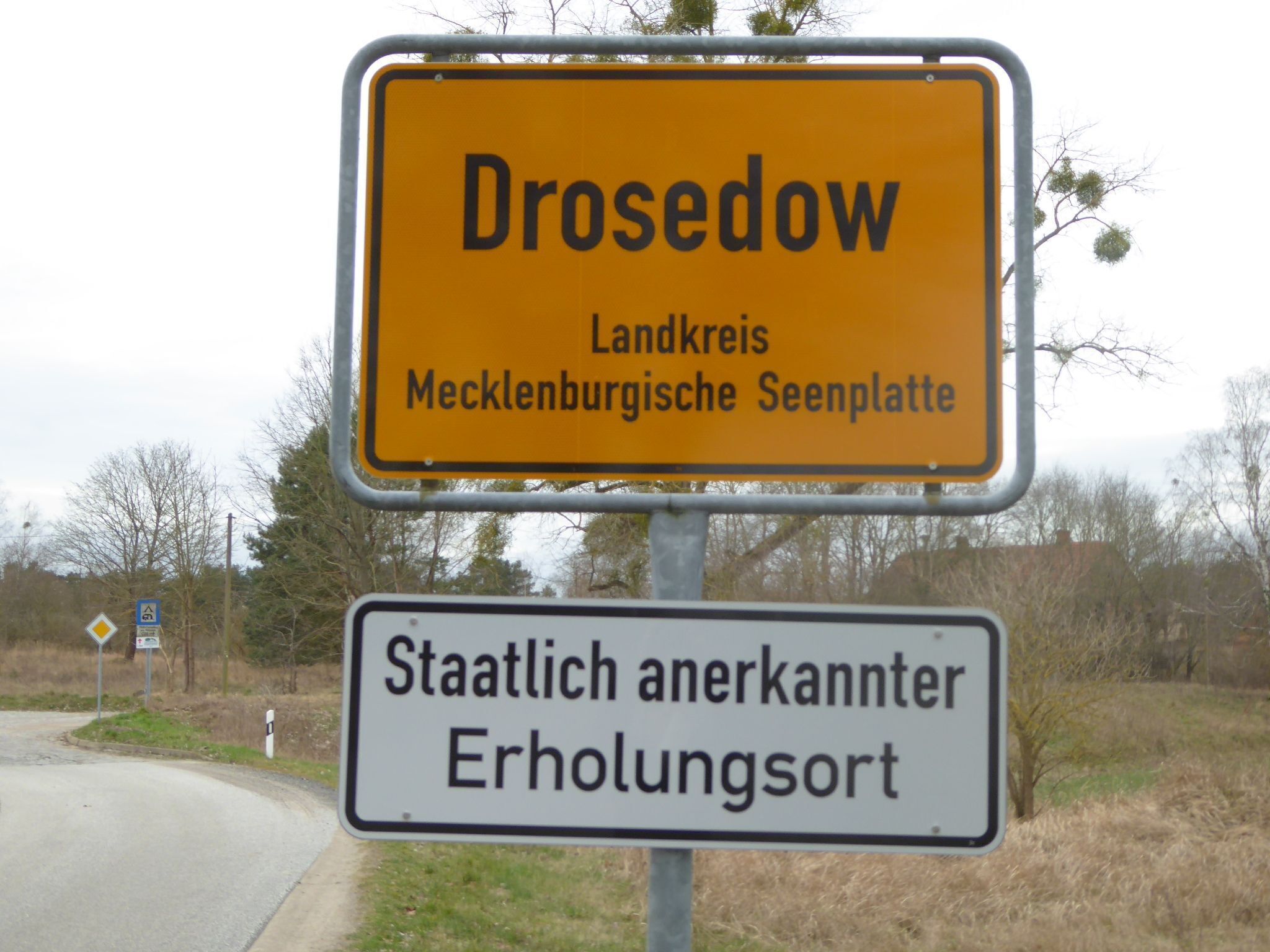 A road sign with the text "Drosedow" and "Landkreis Mecklenburgische Seenplatte".