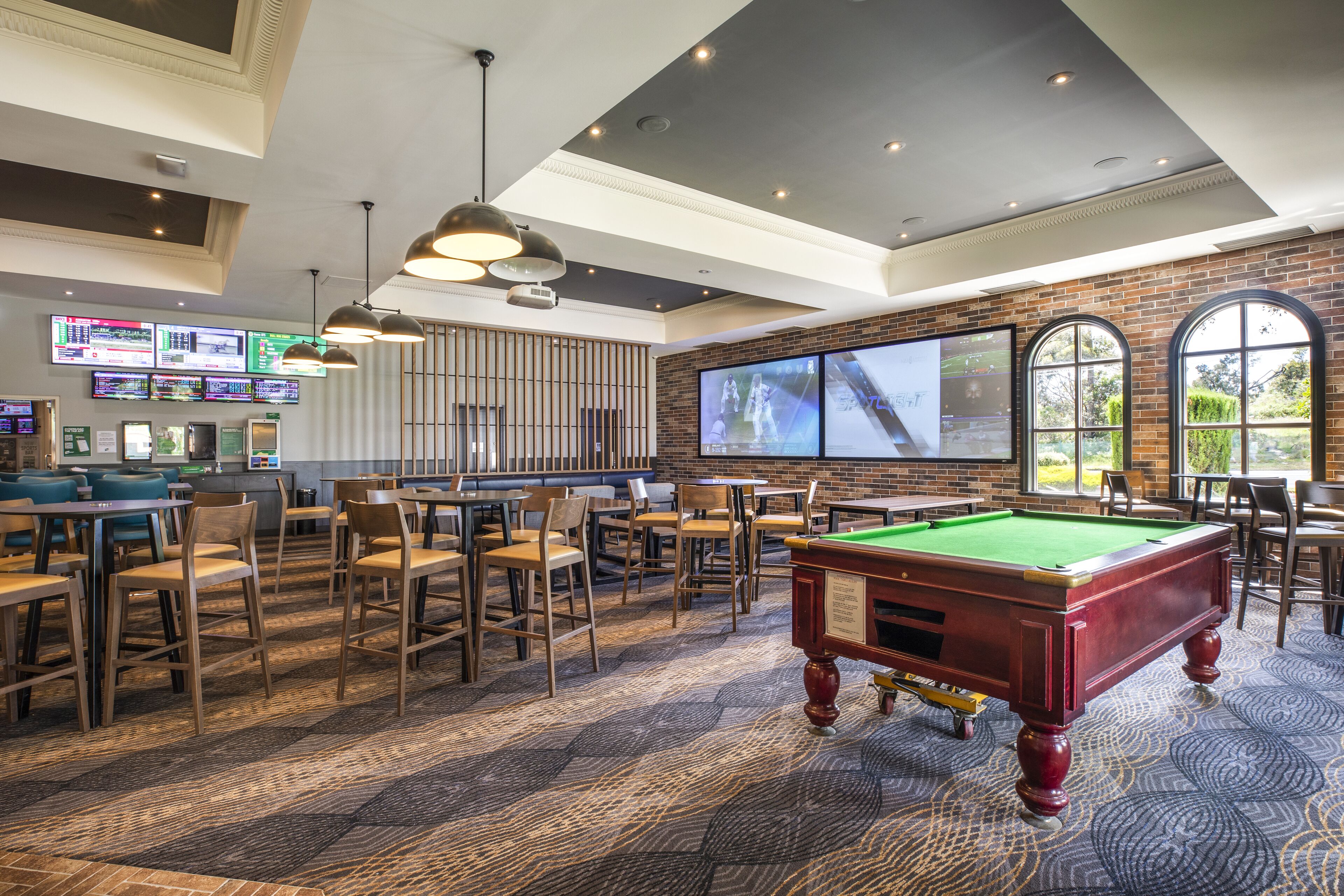 A billiards room with tables, chairs, and a pool table.