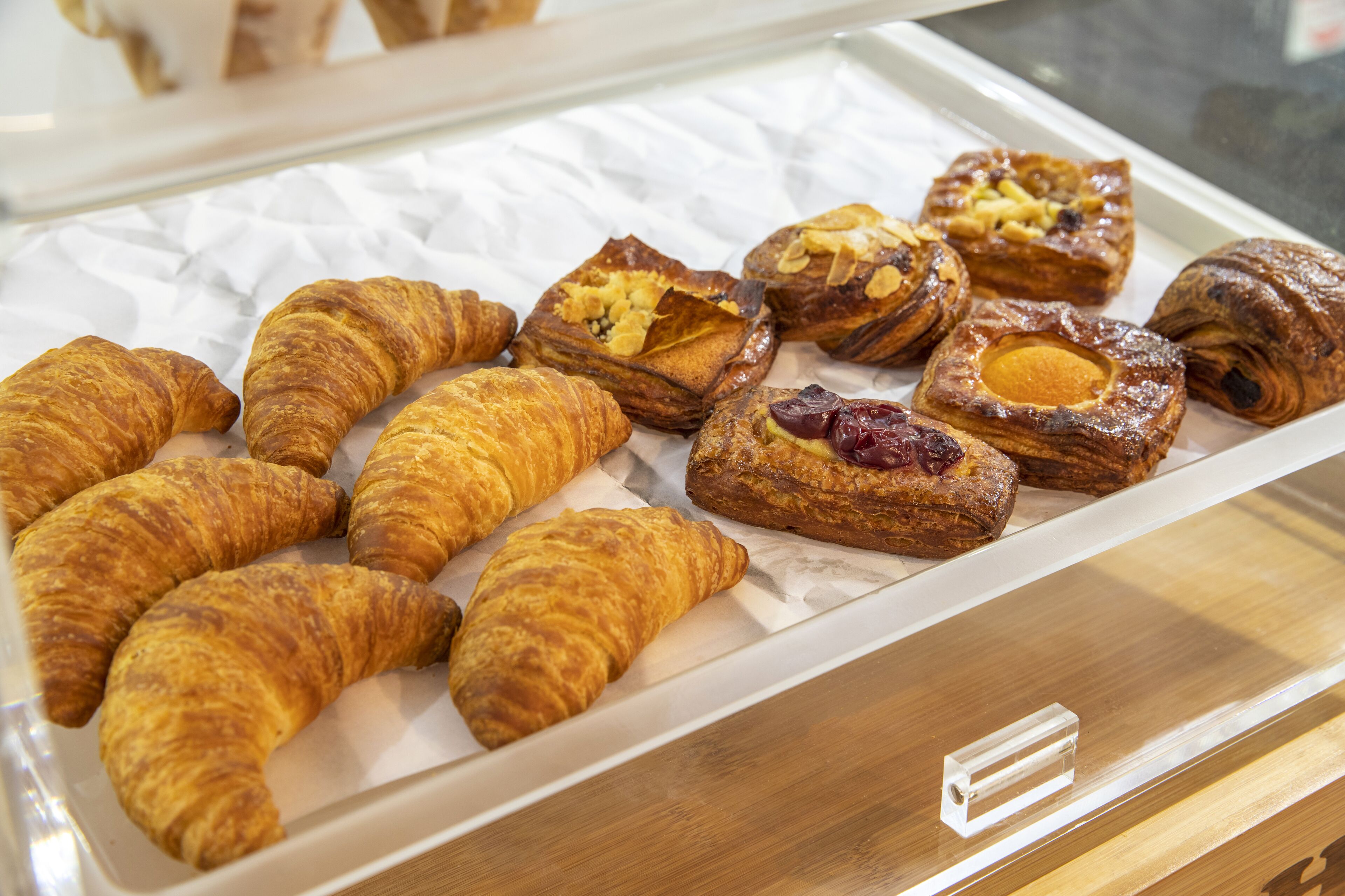 A display of assorted pastries, including croissants and filled pastries, arranged on a tray.