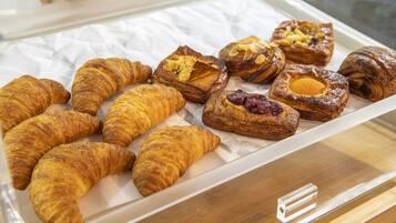 A display of assorted pastries, including croissants and filled pastries, arranged on a tray.