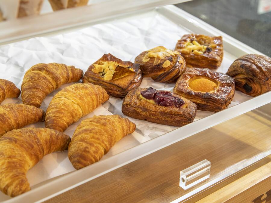 A display of assorted pastries, including croissants and filled pastries, arranged on a tray.