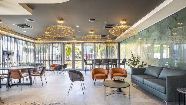 Un interior moderno con comedor, sofás y un ventanal con vistas.