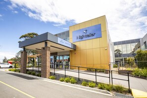 A modern hotel with a reception area, a covered entrance, and a glass facade. - Nightelier Carrum Downs Sands Hotel (Carrum Downs)