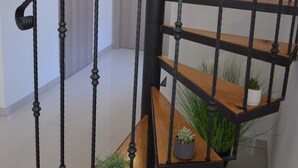 Eine Treppe mit schwarzen Metallgeländern und Holzbeschlägen.