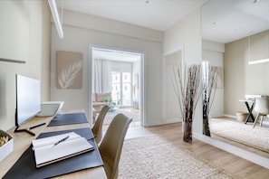 Enjoy a calm and inviting space with a large TV, comfortable sofa, and workspace.