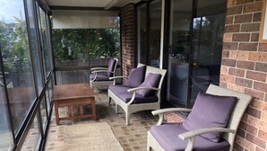 A covered patio with wicker furniture and a wooden table. - Sandy Shores - popular location (Vincentia)