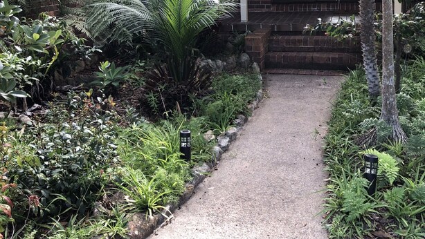 A garden path leading to a building with a brick facade and large windows. - Sandy Shores - popular location (Vincentia)