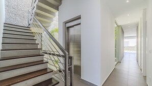 Un interior moderno con una escalera, una puerta y un pasillo.