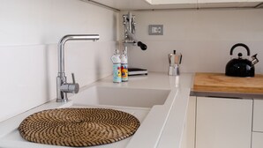 A modern kitchen with a stainless steel sink, a kettle, and a coffee maker on the countertop. - Agatea a due passi dal Duomo by Wonderful Italy (Catania)