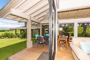Un patio couvert aménagé avec du mobilier d  ’extérieur, une table à manger et un canapé.