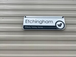 A sign with the name "Etchingham" and the logo of Willerby Holiday Homes. - Pool-garden-2br-parking-wifi-sleeps6 (Paignton)