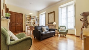 A living room with a fireplace, a bookshelf, a sofa, and a dining area. - GuestHost - Elegant 110 sqm apartment, which can accommodate up to 3 people, located on the fourth floor of a period building with lift (not suitable for the disabled). The property, in the Traffic Restricted Area (ZTL), is located in the heart of the hi (Roma)