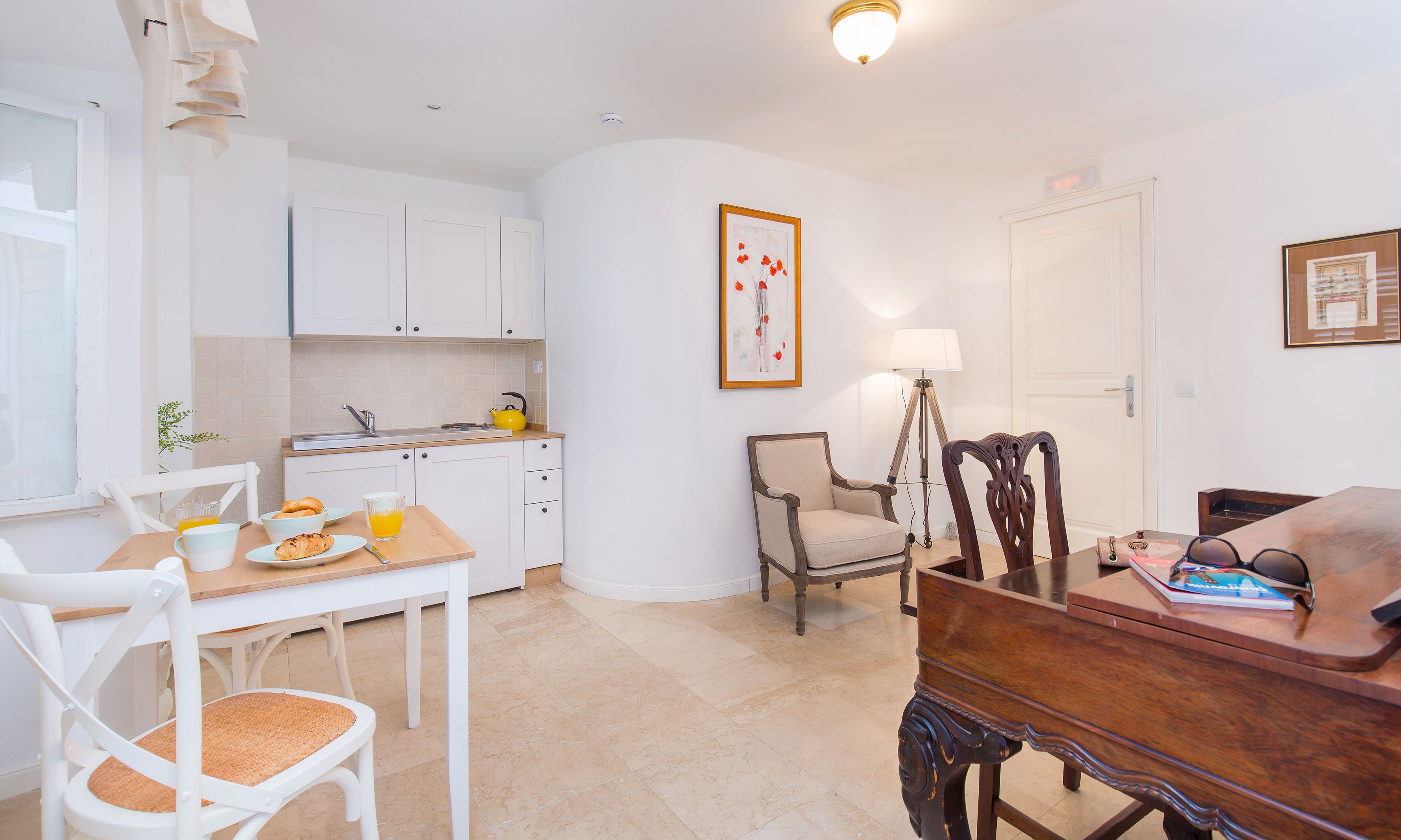 A compact living space with a kitchenette, dining area, and a small seating area.