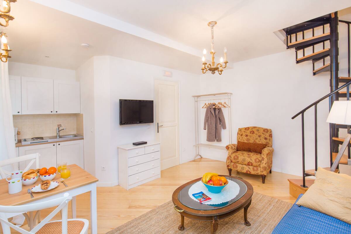 A compact living space with a kitchen, dining area, and a bedroom.