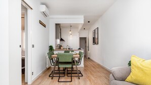 Un appartement moderne comprenant un coin repas, une kitchenette et un salon.