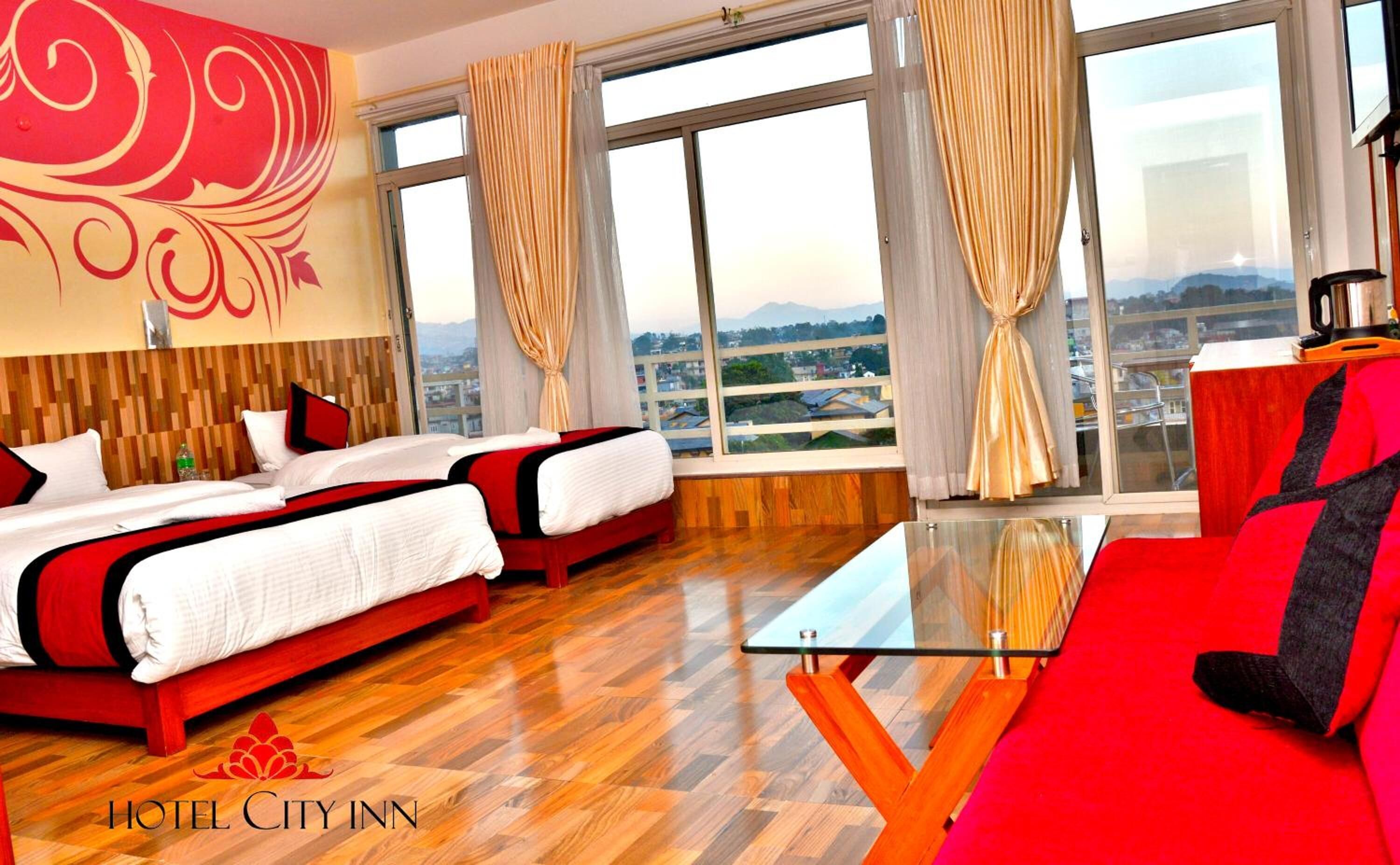 Une chambre d’hôtel avec deux lits, une table basse en verre et une vue sur la ville.