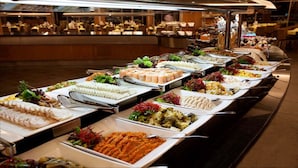 A buffet with various dishes, including salads, meats, and desserts, arranged on a long table. - Grand View Palace Ha Long Hotel (Hong Gai)