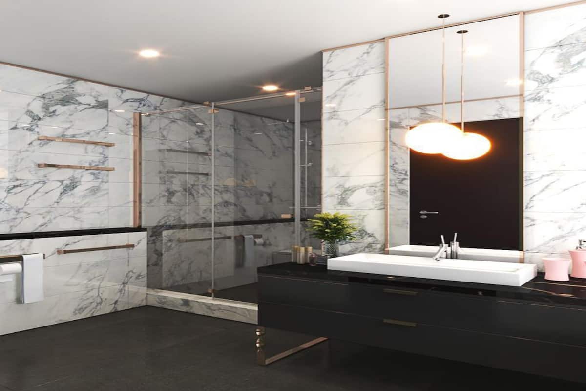 A modern bathroom with a marble backsplash, a glass shower enclosure, and a black vanity with a white sink.
