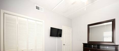 A bedroom with a bed, a television, a dresser, and a chair.