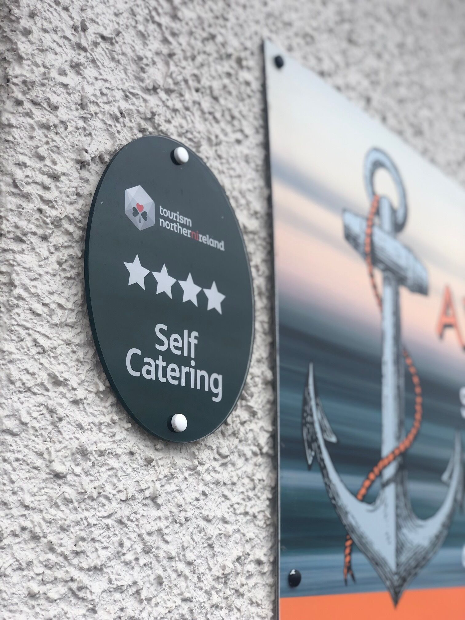Ein Schild mit der Aufschrift 'Self Catering', dem Tourismus Nordirland Logo und einer Sternebewertung.