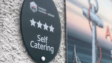 Ein Schild mit der Aufschrift 'Self Catering', dem Tourismus Nordirland Logo und einer Sternebewertung.
