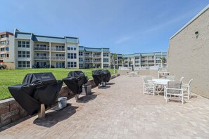 Un espacio al aire libre con mobiliario para sentarse y parrillas.