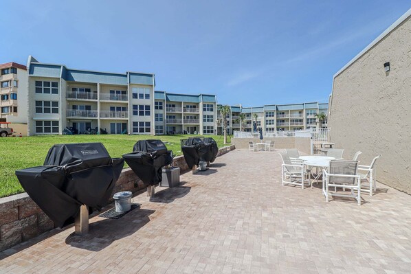A patio area with outdoor seating and barbecue grills.
